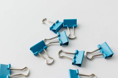 mavi arka planda mavi kağıt klipleri yığını