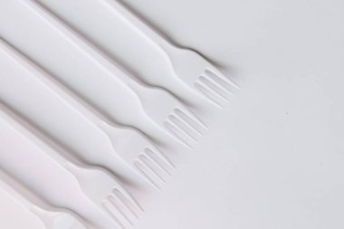 beyaz plastik çatal düz beyaz arka plan üzerinde yatıyordu