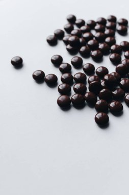 Beyaz arka planda dağınık çikolata draje yığını