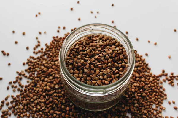 Jar Scatterd Raw Buckwheat White Background — Stock Photo, Image