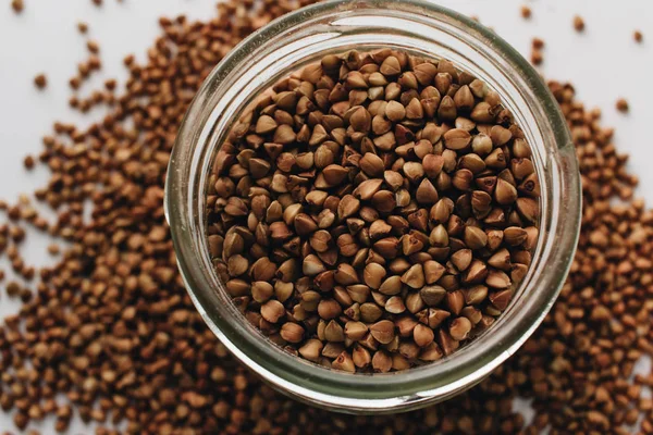 Jar Scatterd Raw Buckwheat White Background — Stock Photo, Image