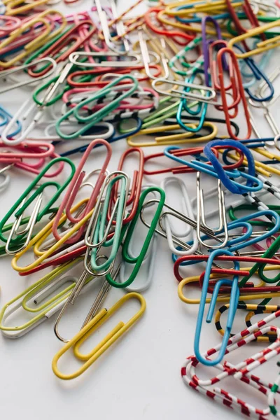 pile of colorful paper clips on white background, flat lay