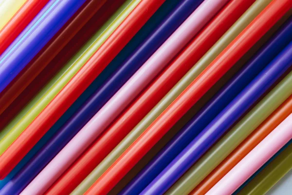pile of colorful cocktail straws over white background