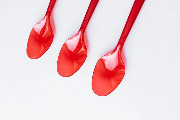 Red Plastic Spoons Flat Lay White Background — Stock Photo, Image