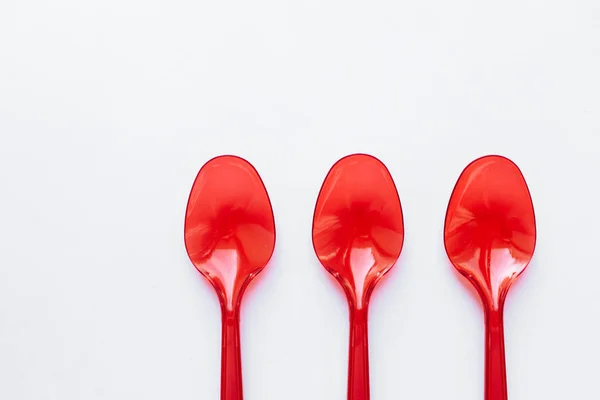 Red Plastic Spoons Flat Lay White Background — Stock Photo, Image