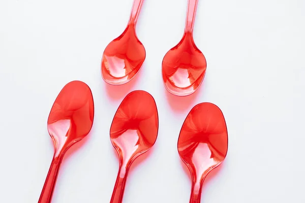 Red Plastic Spoons Flat Lay White Background — Stock Photo, Image