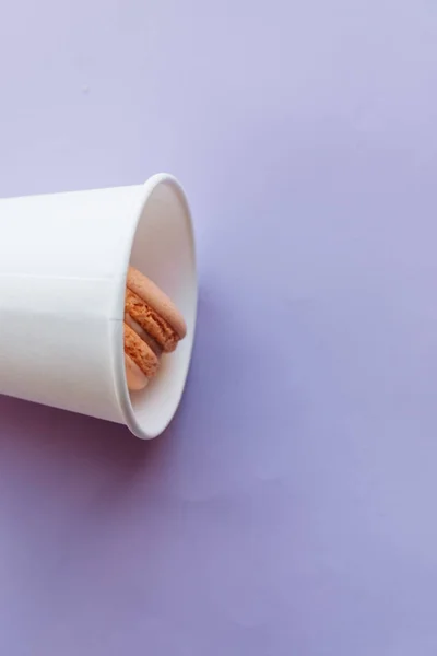 Composición Deliciosos Macarrones Taza Plástico Sobre Fondo Púrpura — Foto de Stock