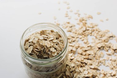 beyaz arka plan üzerinde ham yulaf gevreği ile kavanoz