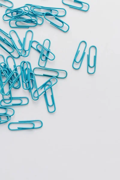 stock image pile of blue paper clips on blue background