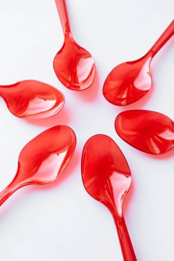 kırmızı plastik kaşık düz beyaz arka planda yatıyordu