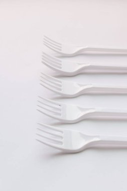 beyaz plastik çatal düz beyaz arka plan üzerinde yatıyordu
