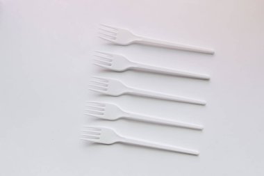 beyaz plastik çatal düz beyaz arka plan üzerinde yatıyordu