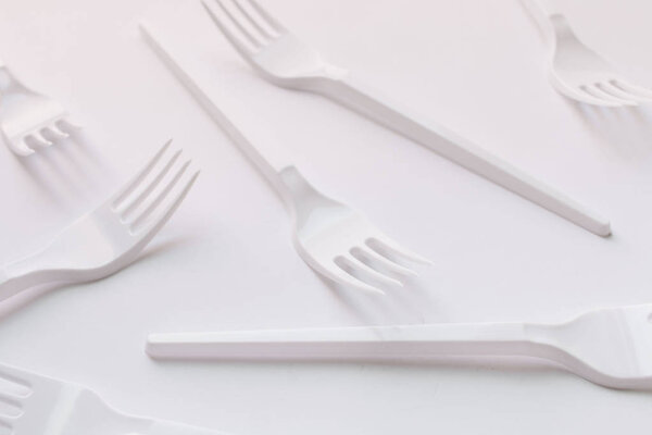 white plastic forks flat lay on white background