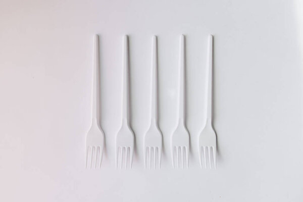 white plastic forks flat lay on white background