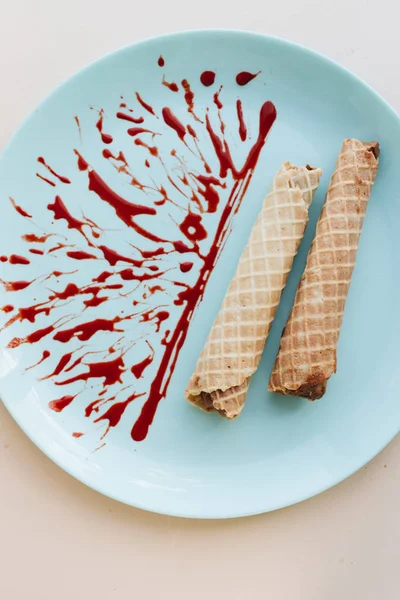 red caramel and waffle tubes with sweet filling  on plate