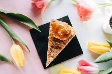 çiçekler ile arka planda lezzetli taze kek parçası