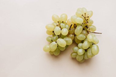 Bej arka planda bir demet beyaz üzüm