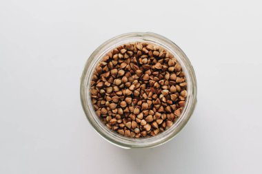 Beyaz arkaplanda dağınık ham karabuğday, 