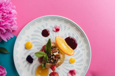 Fındık ve ballı makroyla doldurulmuş fırında elma. Sağlıklı yemek, pembe ve mavi arka plan