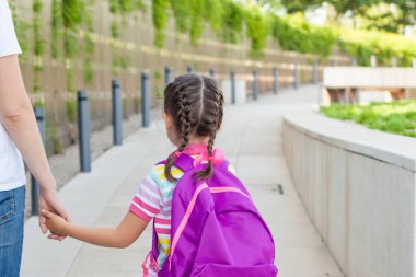 Okuldaki ilk gün. anne birinci sınıfta küçük bir çocuk okul kız yol açar. okula geri kavram