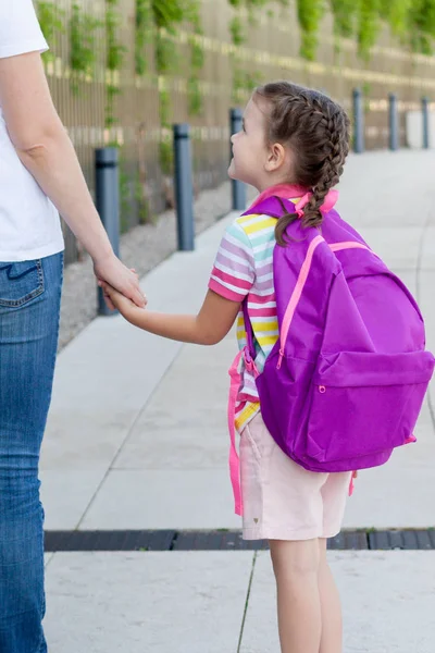 first day at school. mother leads a little child school girl in first grade. concept back to school