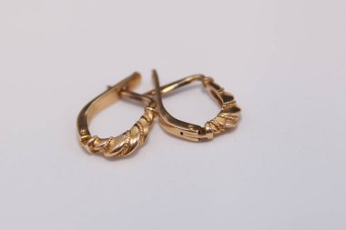 Beyaz arka planda altın küpeler