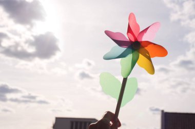 Gökkuşağı renkli fırıldak karşı bulutlu gökyüzü güneş ile düzenlenen sh