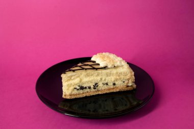 Siyah plat üzerinde krema ve çikolata cips ile katman pasta dilimi