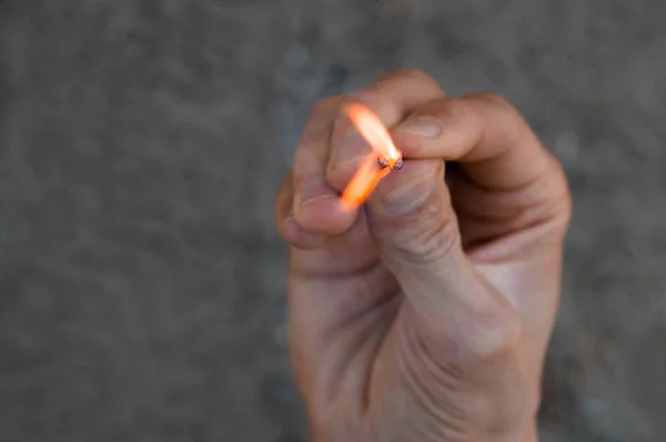 Rechte Hand Eines Erwachsenen Mannes Hält Ein Streichholz Mit Straßenhintergrund — Stockfoto