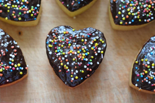 Tatlı ve çikolata tozu ile tepesinde lezzetli kalp şeklinde hava cupcakes.