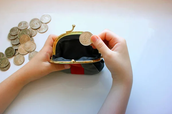 American dollars in a coin purse on a white background. Close-up of the hand. The concept of saving money in crisis and home finances, savings.