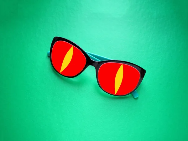 colored sunglasses  on a green background, color contrast