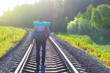 bir sırt çantası ile bir demiryolu tuval, konsept seyahat, tonda yürüyen adam
