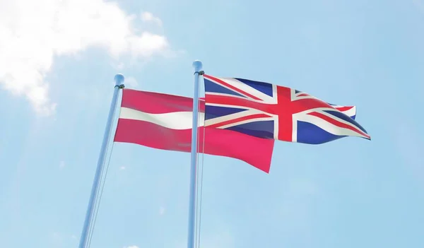Letonia Reino Unido Dos Banderas Ondeando Contra Cielo Azul Imagen — Foto de Stock