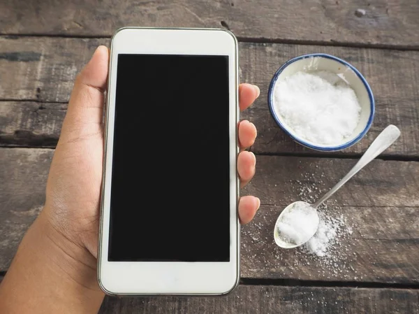 Smart phone on hand and salt