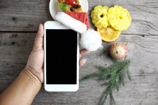 Noel şapka ve meyve kek ile akıllı telefon
