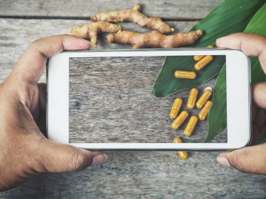 Akıllı telefon ile zerdeçal kapsül yandan fotoğrafta