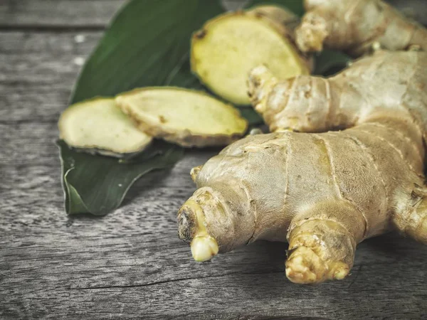 Ginger and leaves on wood background