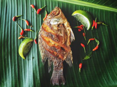 Kızarmış balık üzerinde yeşil muz yaprak Tay yiyecek