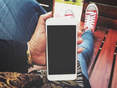 Yandan akıllı telefon kullanan kadın ve spor ayakkabı