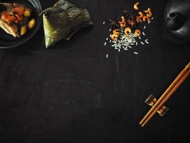 Çaydanlık siyah arka planda Çin yemeği ile Zongzi