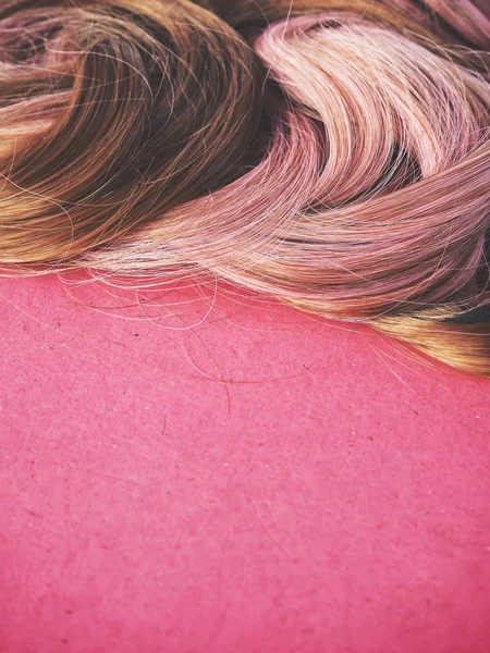 Wig hair on pink background