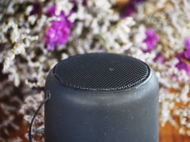 Siyah Bluetooth hoparlör ve çiçek