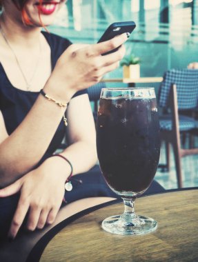 Restoranda el ve kola içeceği akıllı telefon kullanan kadın