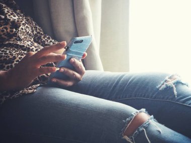 Kadın kanepede el akıllı telefon kullanarak