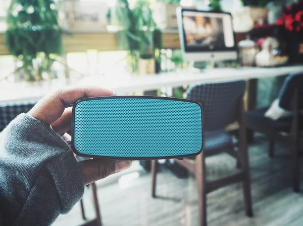Selfie of bluetooth speaker on hand with sneakers