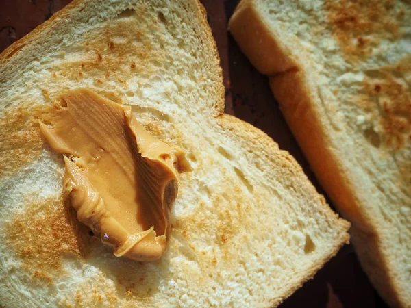 Śniadanie z plasterkiem chleb tostowy z masłem orzechowym — Zdjęcie stockowe