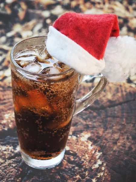 Cola drink z kostkami lodu i kapeluszem świątecznym — Zdjęcie stockowe