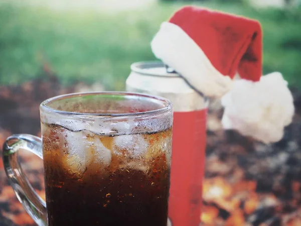 Cola drink z kostkami lodu i kapeluszem świątecznym — Zdjęcie stockowe