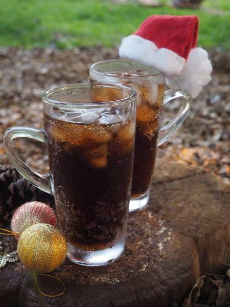 Cola drink z kostkami lodu w świątecznym kapeluszu — Zdjęcie stockowe